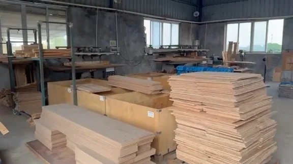 Rectangular panels stacked in front of woodworking equipment