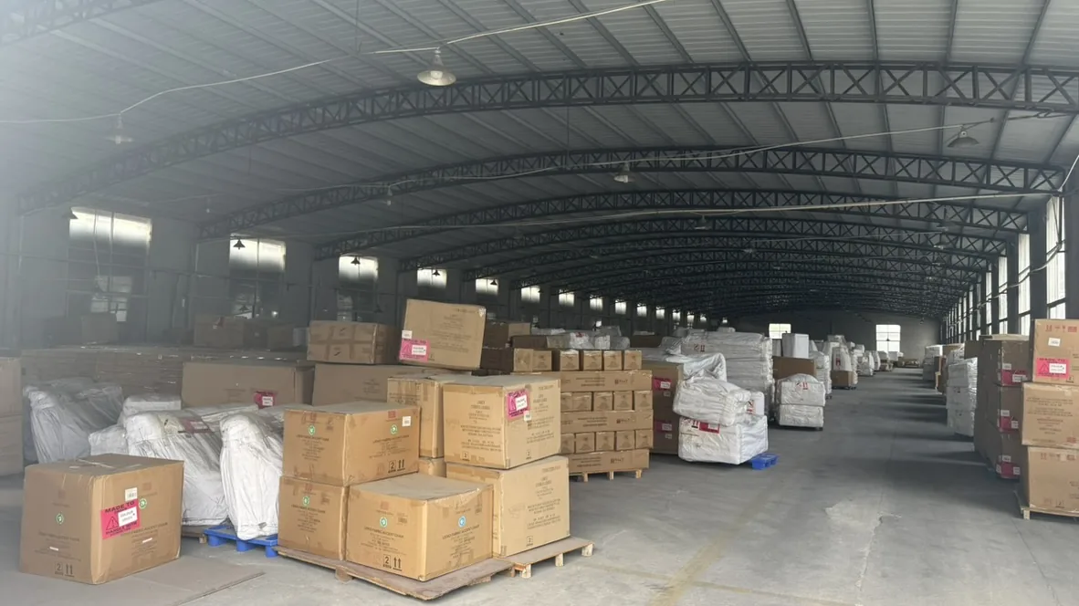 Wide view of cartons and white wrapped packages on pallets