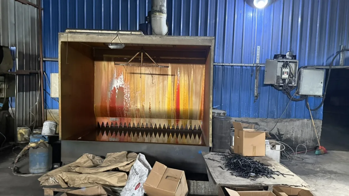 Close-up of a suspended work booth and small metal parts