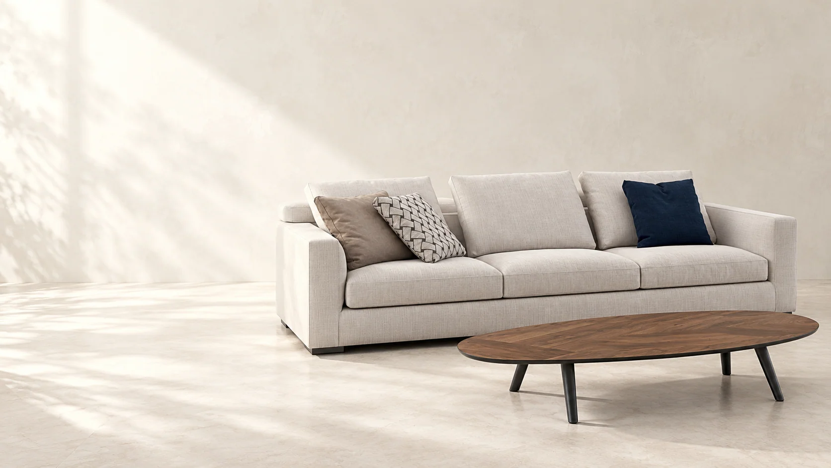An oatmeal three-seat sofa and oval coffee table in a softly lit neutral interior