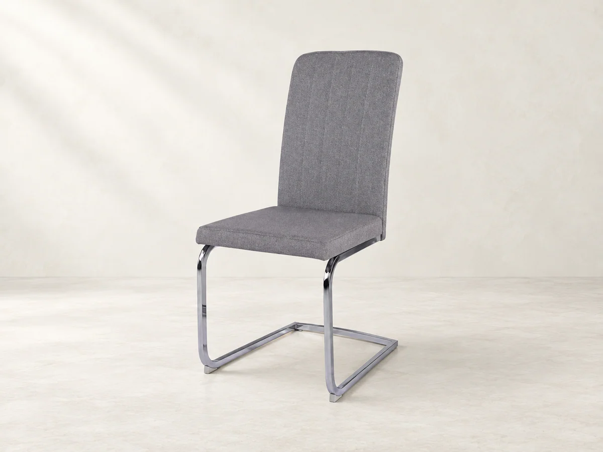 Light-grey fabric dining chair with a chrome cantilever frame