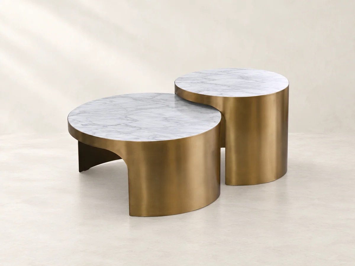 Two round nesting tables with pale patterned tops and metallic bases